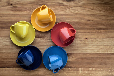 Colorful empty coffee cups on wooden background の写真素材