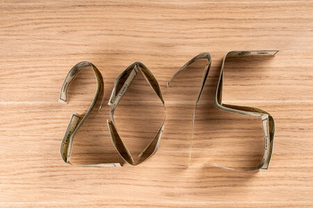 One hundred dollars in shape of 2015. New year concept on wooden background.の写真素材