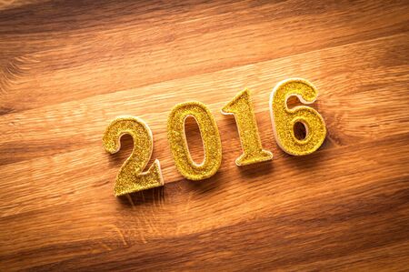 2016 year golden number on wooden background. New year decoration.の写真素材