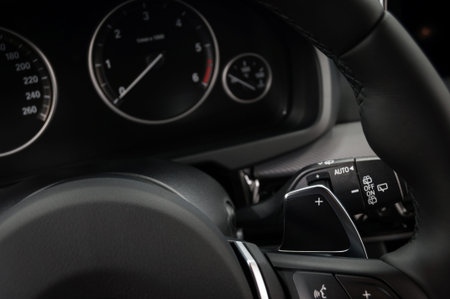 Manual gear changing stick on a car's steering wheel, Modern car interior details.