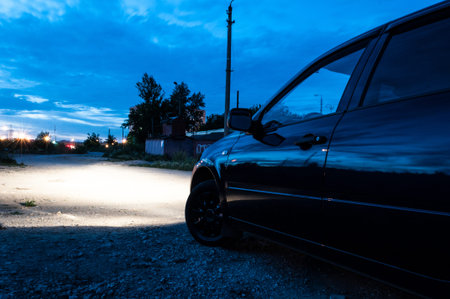 car side view from behind. polished car. night. headlights lightの写真素材