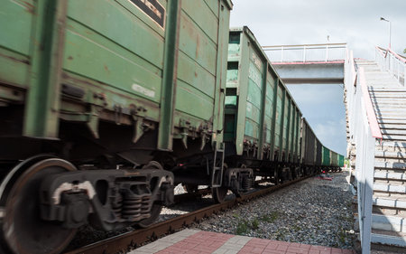 Railway freight cars pass by. Movement of a freight train past the station platform. Wagons carrying...