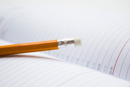 Pencil in a composition with a blank bookの写真素材