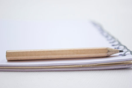 Pencil in a composition with a blank bookの写真素材