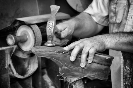 Shoemaker, repairing heels in black and whiteの写真素材