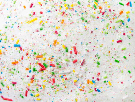 Confectionery decoration confetti on a white sugar glaze の写真素材
