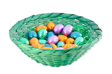 Isolated colorful chocolate eggs in a green basketの写真素材