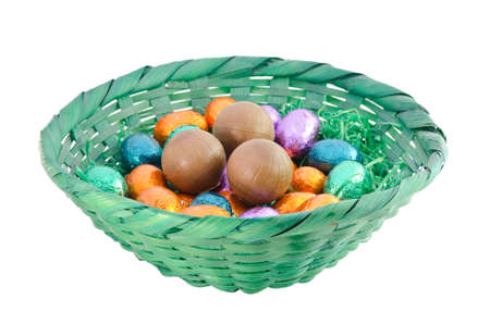 Isolated colorful chocolate eggs in a green basketの写真素材