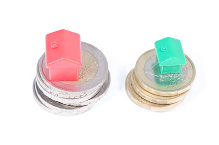 Toy houses on coins, on a white backgroundの写真素材