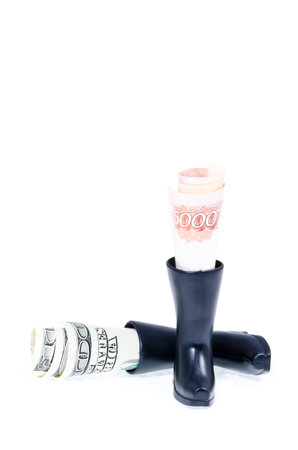 Five thousand Russian rubles and one hundred dollars in the toy boots on white backgroundの写真素材