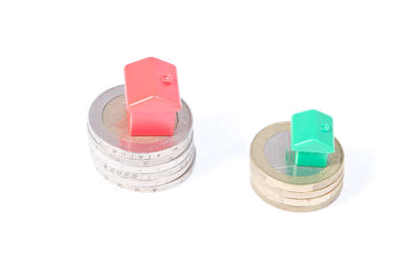 Toy houses on coins, on a white backgroundの写真素材