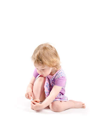 Isolated shot of little fashionista playing with a nail oilの写真素材