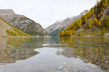 A serene mountain lake, gray of the autumn sky in Levignoの写真素材