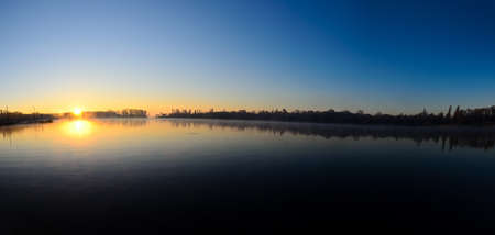 Panoramic photo of the sunrise over the lakeの写真素材