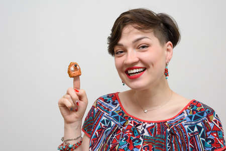 Portrait of a girl with a ceramic hedgehog on a gray backgroundの写真素材