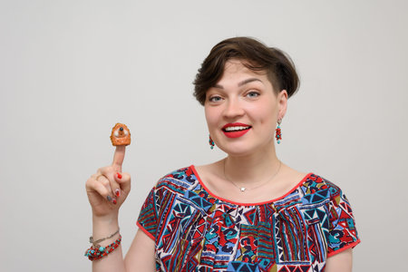 Portrait of a girl with a ceramic hedgehog on a gray background