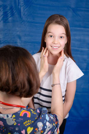 Photo of a child's examination by a pediatrician on a blue backgroundの写真素材