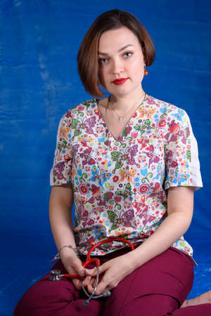 Photo of a pediatrician on a blue background with a stethoscopeの写真素材