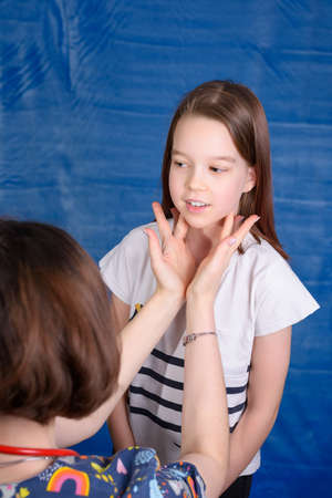 Photo of a child's examination by a pediatrician on a blue backgroundの写真素材