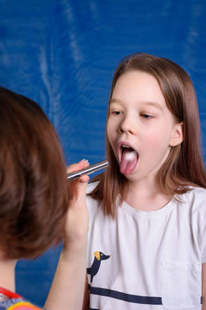 Photo of a child's examination by a pediatrician on a blue backgroundの写真素材