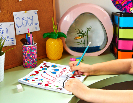 A teenager girl draws in her roomの写真素材