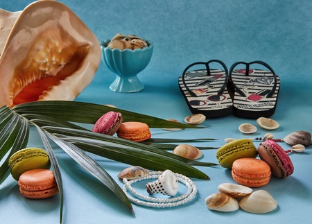Beach accessories, fresh tasty fruit and macaron on a blue background, side view. The concept of summer holidays. Very high resolution imageの写真素材