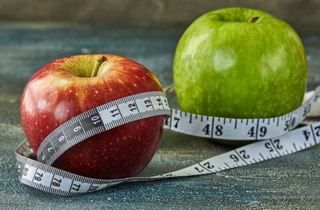 Attributes of a healthy lifestyle. Fruits and meter on a blue with divorces background. Calorie counting. Diet plan. Side view. Close-up. Sport and healthy mode.の写真素材