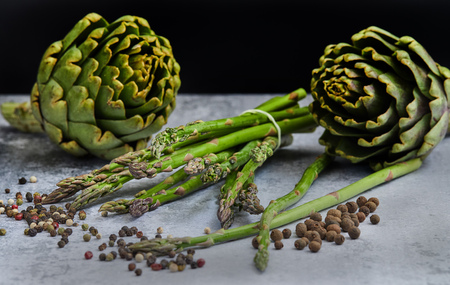 Asparagus and artichokes with herbs on a gray backgroundの写真素材