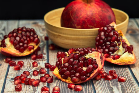 Ripe pomegranate fruit on old brown wooden vintage background.