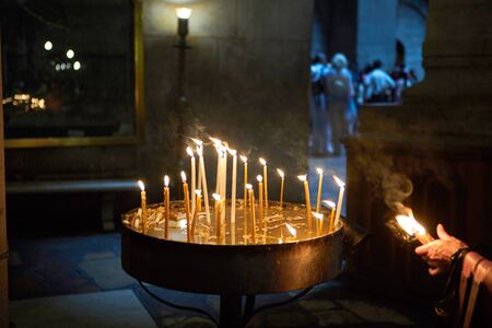 Jerusalem, Israel - July 10, 2019: Many church candles burn in the dark. Candles in the Church of the Holy Sepulcher in Jerusalem.のeditorial素材