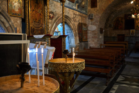 Jerusalem, Israel - July 10, 2019: Many church candles burn in the dark. Candles in the Church in...