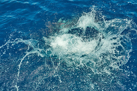 Water splash on the red sea after a jump from a yacht, background texture