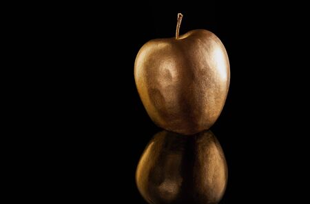 Rosh hashanah - jewish New Year holiday concept. Traditional symbols: whole golden apple on a black background.の写真素材