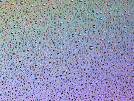Drops on glass of different sizes and colors on a colored background, texture.