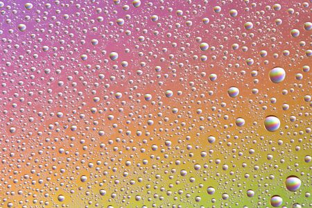 Drops on glass of different sizes and colors on a colored background, texture.の写真素材