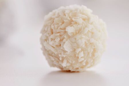 White chocolate candies with coconut filling on a white background. High key photo.の写真素材