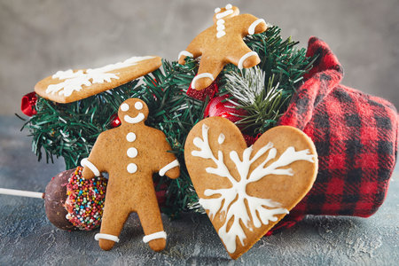 Gingerbread cookie in the shape of hearts and a man on the background of the Christmas tree.