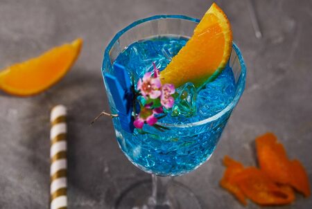 Blue curacao liquor with orange and flower for design on a gray background. Close up.の写真素材