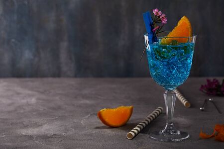 Blue curacao liquor with orange and flower for design on a gray background.の写真素材
