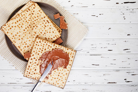 Pesah celebration concept - jewish Passover holiday Background of matzoh smeared with chocolate...