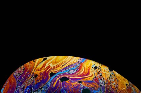 Virtual reality space with abstract multicolor psychedelic planet. Closeup Soap bubble like an alien planet on black background.の写真素材