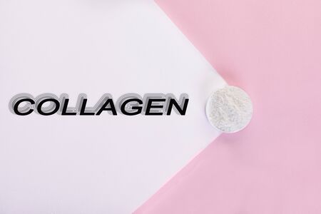 Collagen powder on a pink background. Extra protein intake. Natural cosmetic supplement for skin, bones, joints and intestines. Plant or fish based. Top view. Copy spaceの写真素材