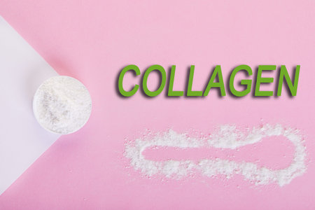Collagen powder on a pink background. Extra protein intake. Natural cosmetic supplement for skin, bones, joints and intestines. Plant or fish based. Top view. Copy spaceの写真素材