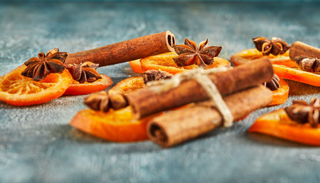 Slices of dried oranges or tangerines with anise and cinnamon, on a blue background. Vegetarianism...