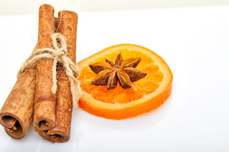 Slices of dried oranges or tangerines with anise and cinnamon, isolated on a white background....