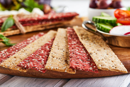 Beetroot and rye flour crackers with vegetables for making snacks on a wooden background....