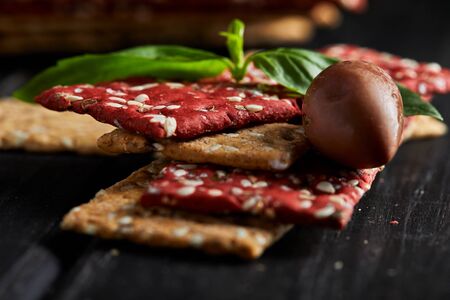 Beetroot and rye flour crackers with vegetables for making snacks on a black background. Vegetarianism and healthy eating. Close upの写真素材