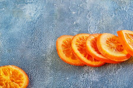 Slices of dried oranges or tangerines on a blue background. Vegetarianism and healthy eating. Copy space.の写真素材
