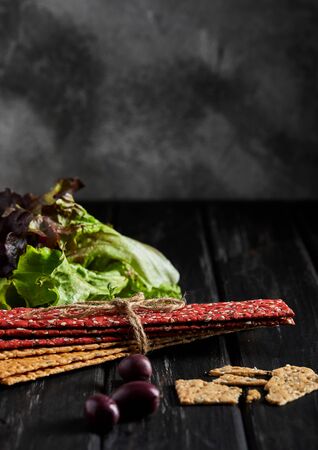 Beetroot and rye flour crackers with vegetables for making snacks on a black background. Vegetarianism and healthy eating. Copy space.の写真素材