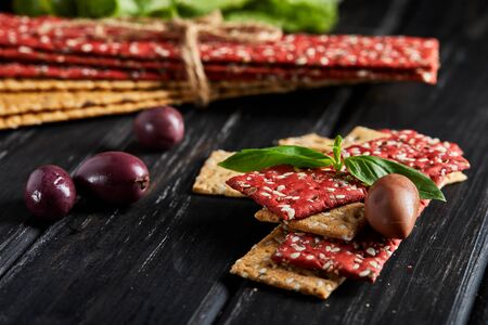 Beetroot and rye flour crackers with vegetables for making snacks on a black background. Vegetarianism and healthy eating.の写真素材